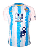 Málaga CF 2024/2025 - Camiseta titular Málaga CF - Hummel Málaga CF - Segunda División - Diseño moderno - Detalles únicos - Málaga - Azul - Blanco - Rojo - Azulejos tradicionales - Gola redonda - Escudo del Málaga CF - Logo de Hummel - Tradición malagueña - Innovación de Hummel - Tecnologías innovadoras - Confort - Rendimiento.